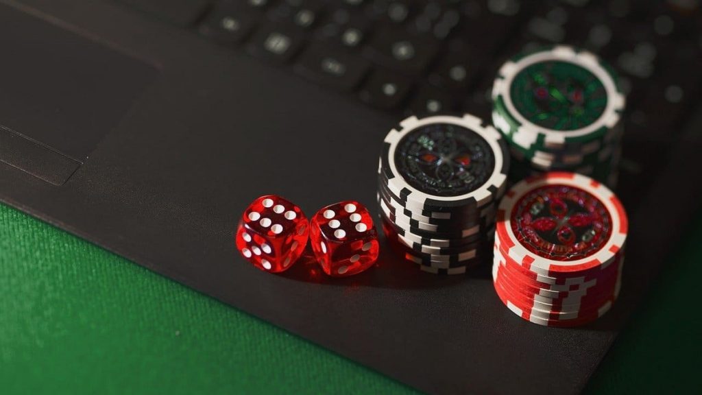 chip poker dan dadu merah diletakkan di laptop
